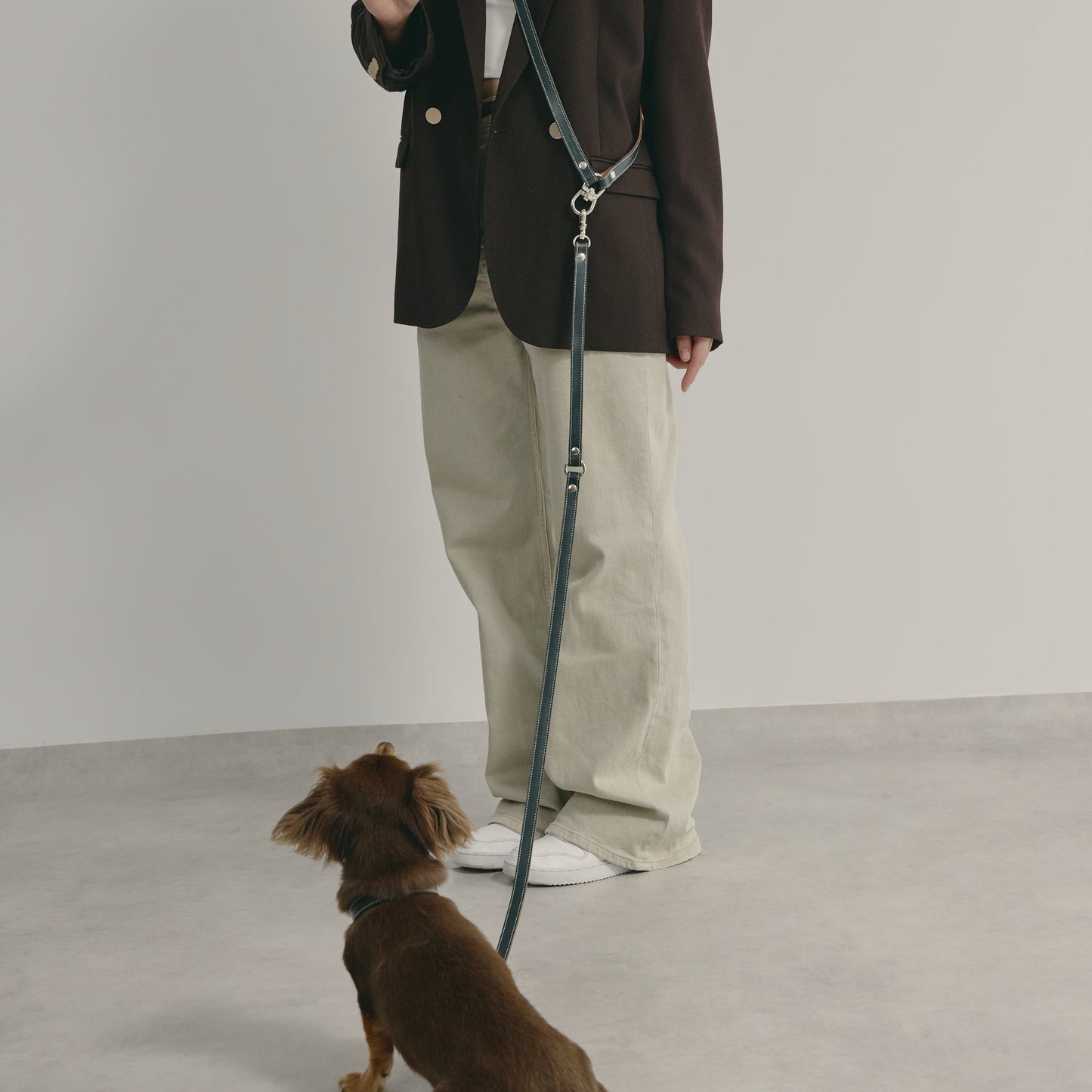 ショルダーリードを肩に掛けて愛犬を待つ様子 - Liberté Beauté